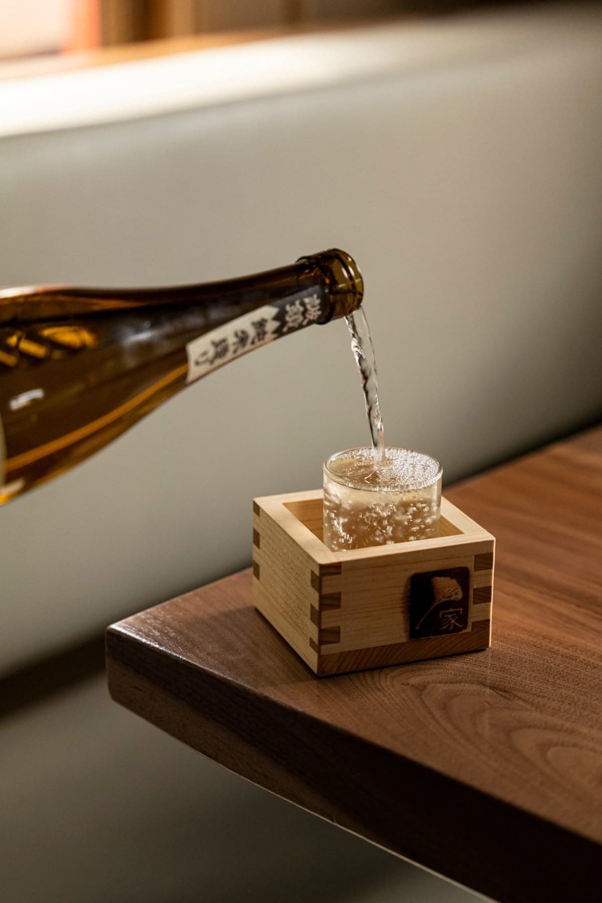 Premium sake being poured into traditional masu